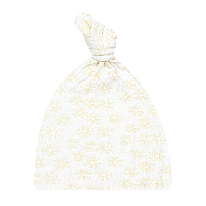 A beige top knot hat with a floral pattern