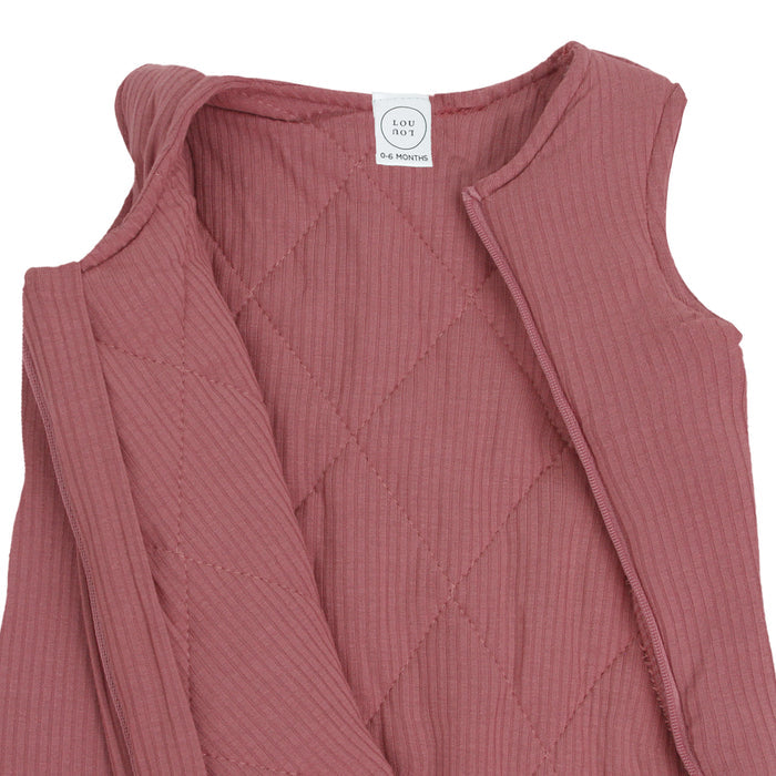 Pink ribbed baby dress with a brand label on a white background
