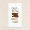 Product display card with hair accessories on a beige background