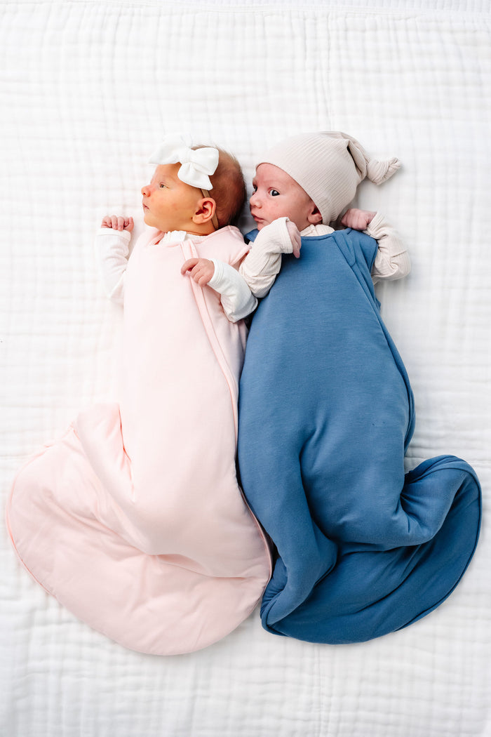 sophie and dean sleep sack newborn girl and newborn boy laying on bed